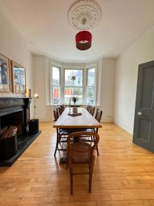 a dining room with a table and chairs and a fireplace at Spacious 4BD Family Home with GardenKensal Green! in London