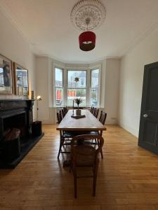 a dining room with a table and chairs and a fireplace at Spacious 4BD Family Home with GardenKensal Green! in London