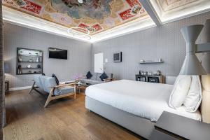 a bedroom with a large white bed and a living room at Martelli 6 Suite & Apartments in Florence