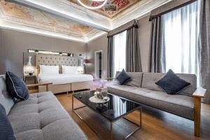 sala de estar con sofá y cama en Martelli 6 Suite & Apartments, en Florencia
