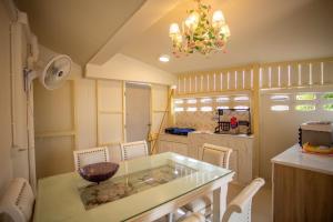 une cuisine avec une table en verre et des chaises blanches dans l'établissement วิลล่าพอใจ, à Chiang Mai