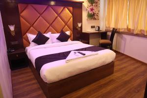 a bedroom with a large bed with a large headboard at Hotel Air Stay Inn - Andheri East in Mumbai