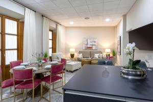 a kitchen and living room with a table and chairs at Genteel Home Plaza de las Tendillas II in Córdoba