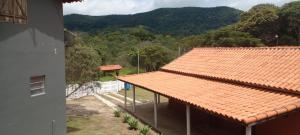 un edificio con techo naranja y vistas a la montaña en Casa na lua, en São Thomé das Letras