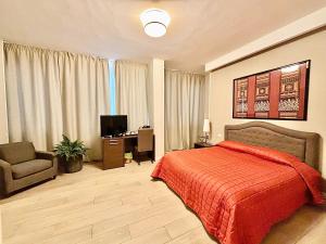 een slaapkamer met een bed, een stoel en een televisie bij Les Suites Luxury Bari Certified Italian Excellence in Bari