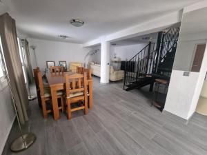 a dining room with a table and chairs and a living room at Casa Clavel in Ronda