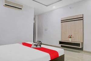 a white room with a bed with a red blanket at Super OYO Flagship 93079 Hotel Paradise in Varanasi