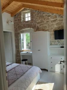 een slaapkamer met een bed en een stenen muur bij Villa Laura - Home Away From Home in Labin