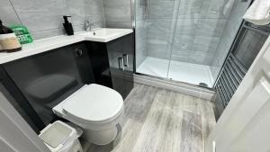 a bathroom with a shower and a toilet and a sink at 202 Grosvenor House - Wakefield in Wakefield