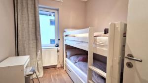 a small room with two bunk beds and a window at Wohnung mit Sauna, Garten & Schwimmteich in Bietigheim-Bissingen