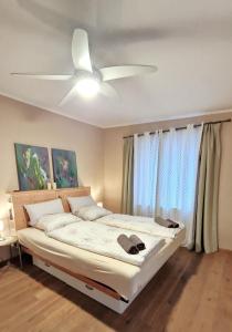 a bedroom with a bed with a ceiling fan at Wohnung mit Sauna, Garten & Schwimmteich in Bietigheim-Bissingen