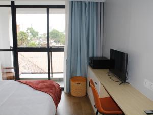 sypialnia z biurkiem, telewizorem i łóżkiem w obiekcie Serene Modern Apartment w mieście Nairobi