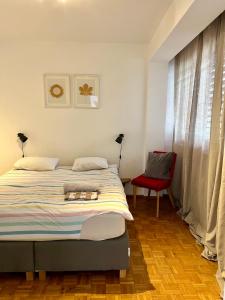 a bedroom with a bed and a red chair at Central 2 bedroom flat in heart of Eaux-vives in Geneva