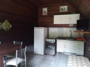 una pequeña cocina con nevera y mesa en Recanto Floripa, en Florianópolis