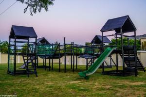 a playground with a slide in a yard at Emerald Gem-Luxury Apartment in Sandton