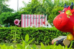 a sign for a garden show with a red dragon statue at Natural Samui Hotel in Bophut