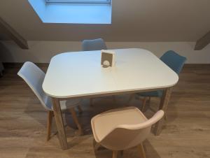 a white table with blue chairs around it at Le Cosy (20' Strasbourg en Bus) in Marlenheim