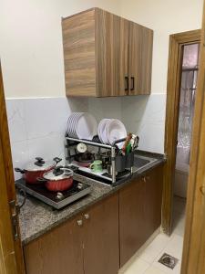 a kitchen with a sink and a stove with dishes at Apartment for rent 50M fully furnished -completely new in Amman