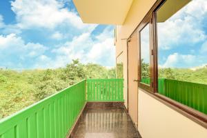 a balcony with a green railing and a window at House Of Comfort Greater Noida Luxury in Greater Noida