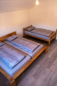 3 łóżka w pokoju z drewnianą podłogą w obiekcie Kuca za odmor Nedo w mieście Kupres