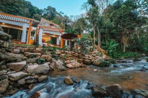 a house with a river in front of it at Pangthara65 ปางธารา ณ ปางไฮ เชียงใหม่ in Doi Saket