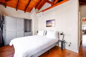 1 dormitorio con cama blanca grande y techo de madera en Homie Suites - Turna Residences in Cihangir, en Estambul