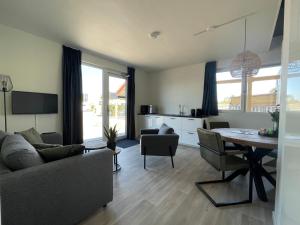 a living room with a couch and a dining room table at Marinaveste Campevaer in Sneek
