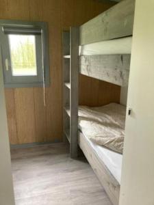 Zimmer mit Etagenbett und Fenster in der Unterkunft Chalet op mini-camping de Peelweide in Grashoek