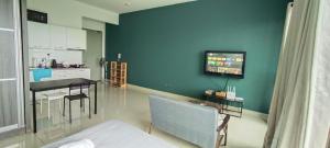 a living room with a table and a tv on a wall at Peacehome 31 in Cyberjaya