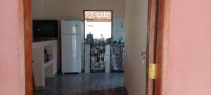 a kitchen with a white refrigerator and a window at Casa na lua in São Thomé das Letras