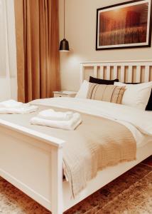 a white bed with two towels on top of it at GIA Apartment in Satu Mare