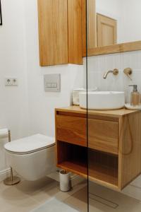 a bathroom with a white toilet and a sink at GIA Apartment in Satu Mare