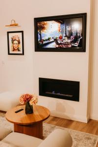 uma sala de estar com uma lareira e uma mesa em GIA Apartment em Satu Mare