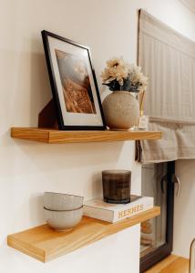 a wooden shelf with a picture and a bowl on it at GIA Apartment in Satu Mare