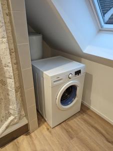 a washer and dryer in a room under a stairs at Le Cosy (20' Strasbourg en Bus) in Marlenheim