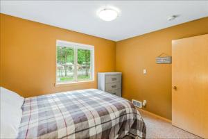 Basecamp Cabin في Greenwater: غرفة نوم بجدران برتقالية وسرير ونافذة