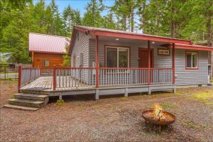 a tiny house with a porch and a fire pit at Basecamp Cabin in Greenwater