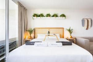 a bedroom with a white bed with plants on the wall at Butan Suite in Callao Salvaje +25 photos