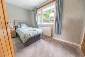 a small bedroom with a bed and a window at Wayside Bungalow in Staveley