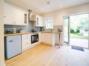 a kitchen with white cabinets and a wooden floor at Purrfect Retreat in Bugle