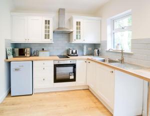 a white kitchen with white cabinets and a sink at Purrfect Retreat in Bugle