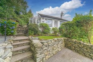 una casa con una pared de piedra y un patio en Wayside Bungalow, en Staveley