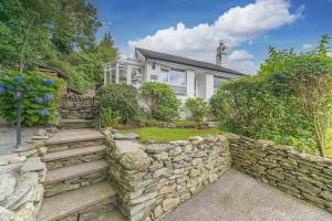 a house with a stone wall and a yard at Wayside Bungalow in Staveley