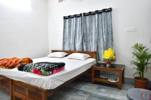 um quarto com uma cama e uma janela em Paradise Inn em Jasidih