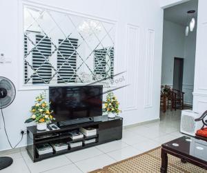a living room with a television and christmas trees at Homestay Klebang Pool in Melaka
