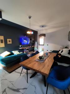 een woonkamer met een houten tafel en blauwe stoelen bij Il quattro e l'otto in Rome
