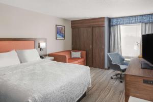 ein Hotelzimmer mit einem Bett, einem Schreibtisch und einem Stuhl in der Unterkunft Hampton Inn Joliet/I-55 in Joliet