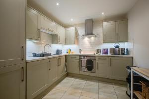 una cocina con armarios blancos y fregadero en Stylish Retreat - 2Bed Home with Exposed Beams - Apex Stays, en Stamford