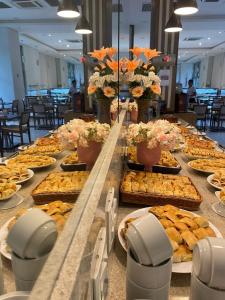 a buffet with plates of food on a table at Flat Premiere in Rio de Janeiro