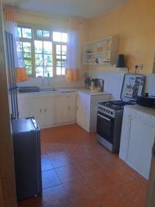 a kitchen with white cabinets and a stove at Elite stays kisumu in Kisumu